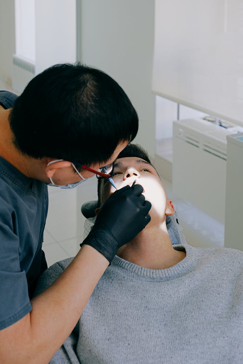 A dentist performing a dental check-up on a patient in a clean, modern clinic setting.